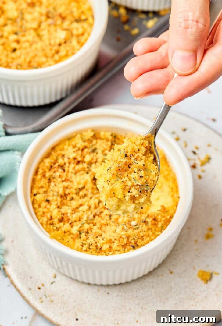 Close-up of a bite of squash casserole on a fork, highlighting its creamy texture and golden topping