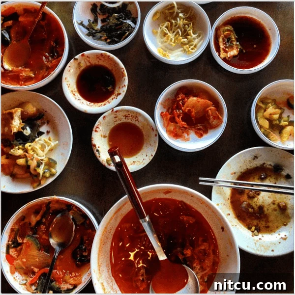 Several half-empty white bowls filled with classic Korean side dishes.