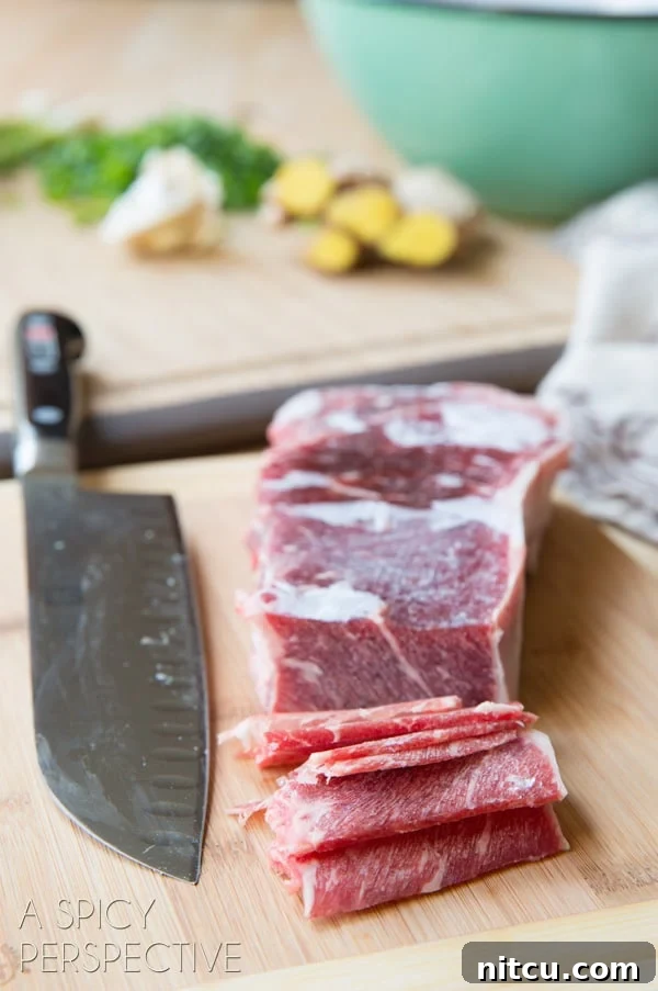Slicing steak into thin slices on a cutting board with a chef's knife.