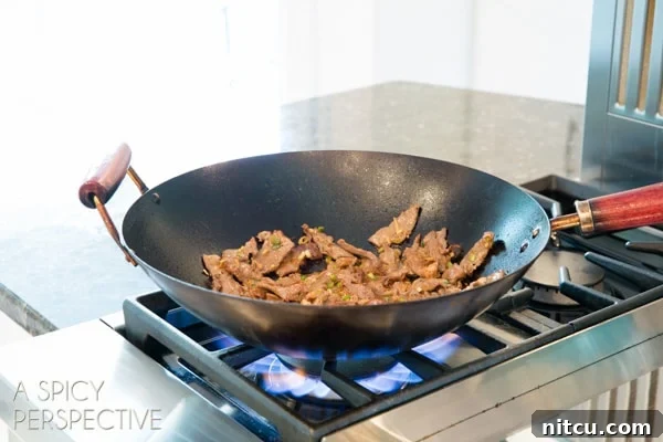 Korean beef bulgogi cooking in a black wok.