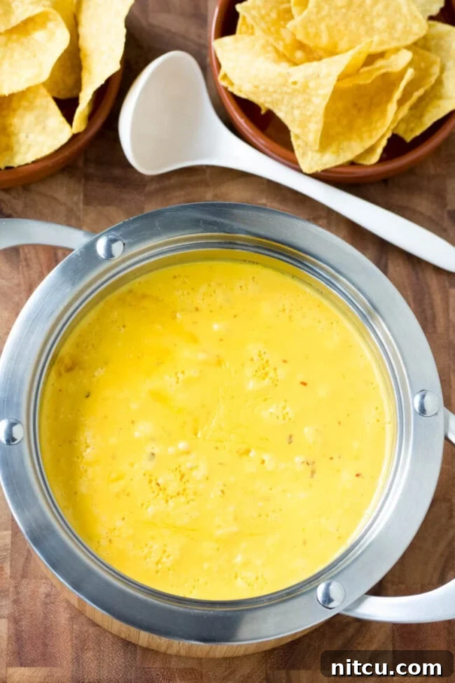 Homemade queso recipe in a rustic pot, steaming and ready to be served.