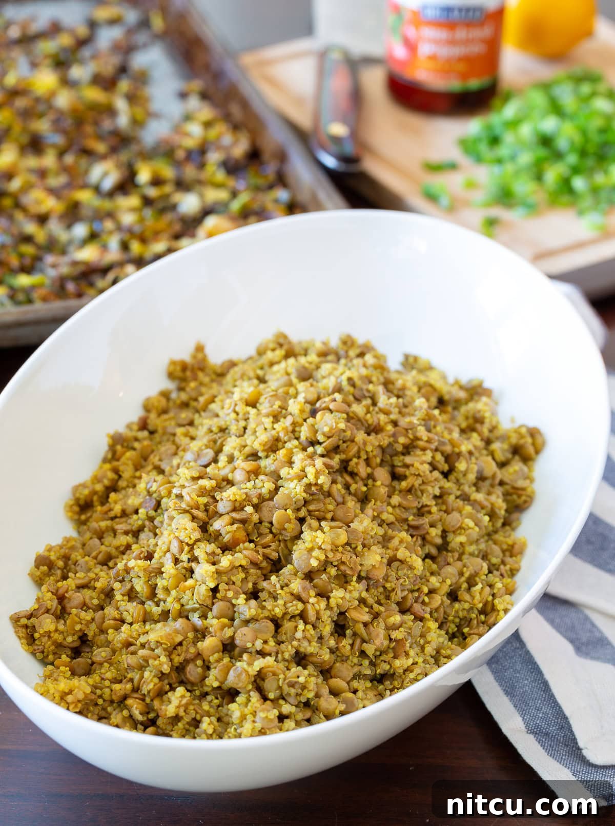 Close-up aerial view of fluffy quinoa and firm lentils mixed in a bowl, ready for the other salad ingredients.