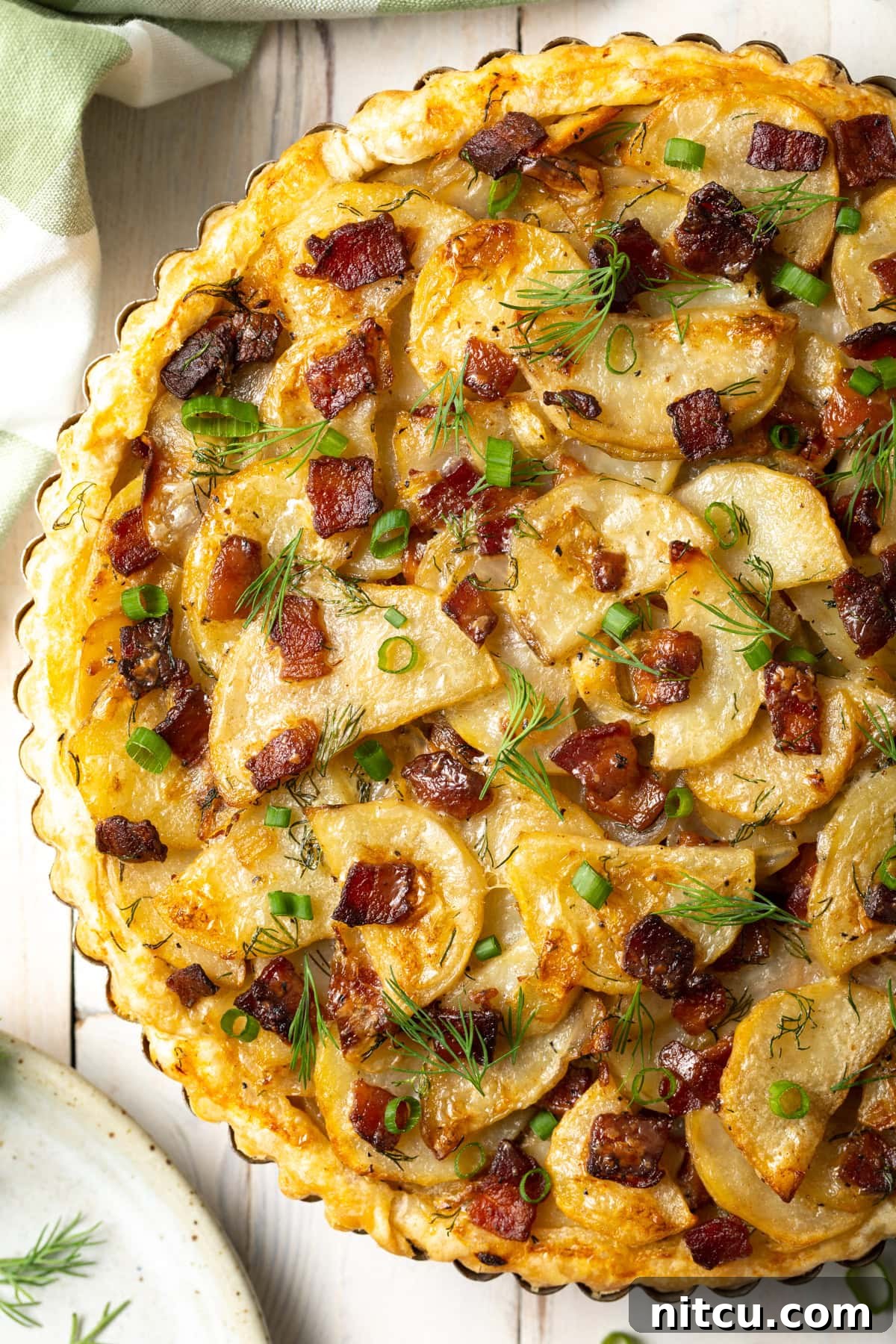Overhead shot of Irish potato pie in a tart tin, showcasing its golden-brown crust and inviting layers.