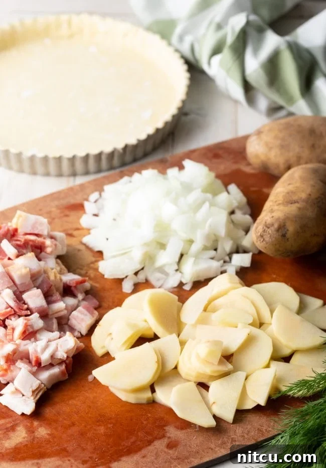 Various ingredients laid out on a kitchen counter, including puff pastry, potatoes, bacon, and herbs, ready for assembling the potato pie.