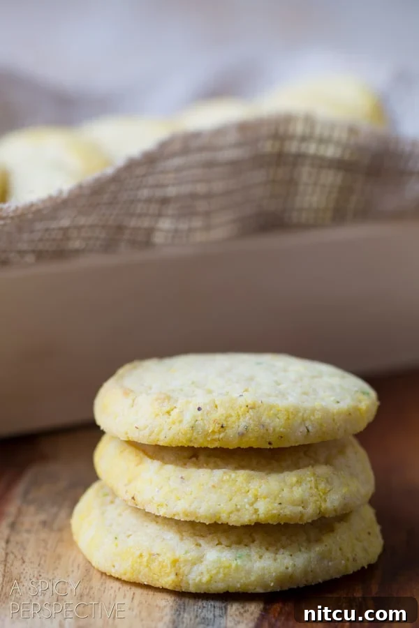 Soft Cornmeal Cookies stacked on a counter with a baking dish in the background, highlighting their homemade appeal.