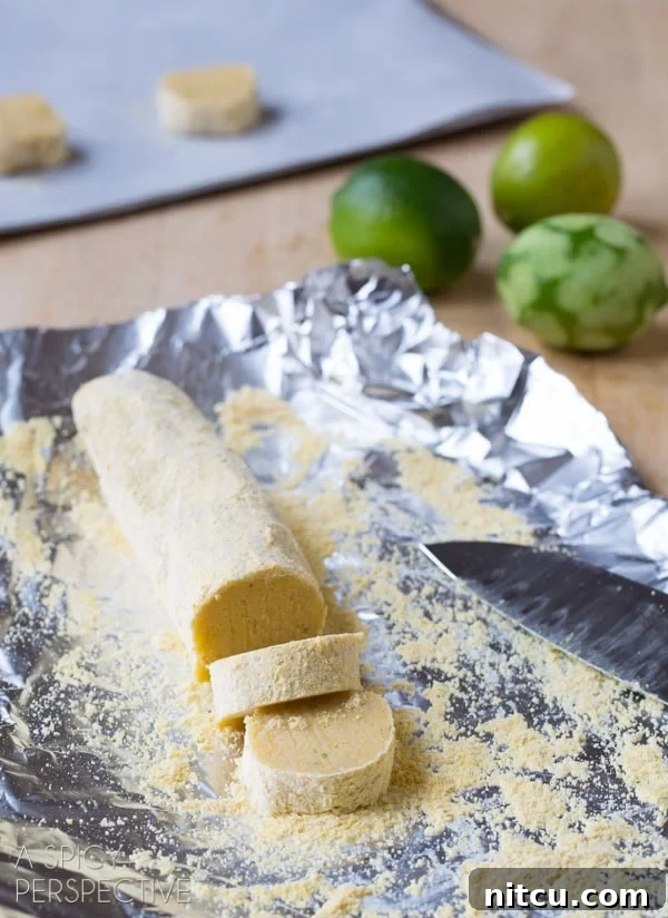 Cookies being sliced from a chilled dough log, ready for baking.