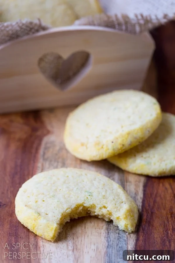 Tender Cornmeal Cookies - a bite taken out of one cookie, showing its soft texture.