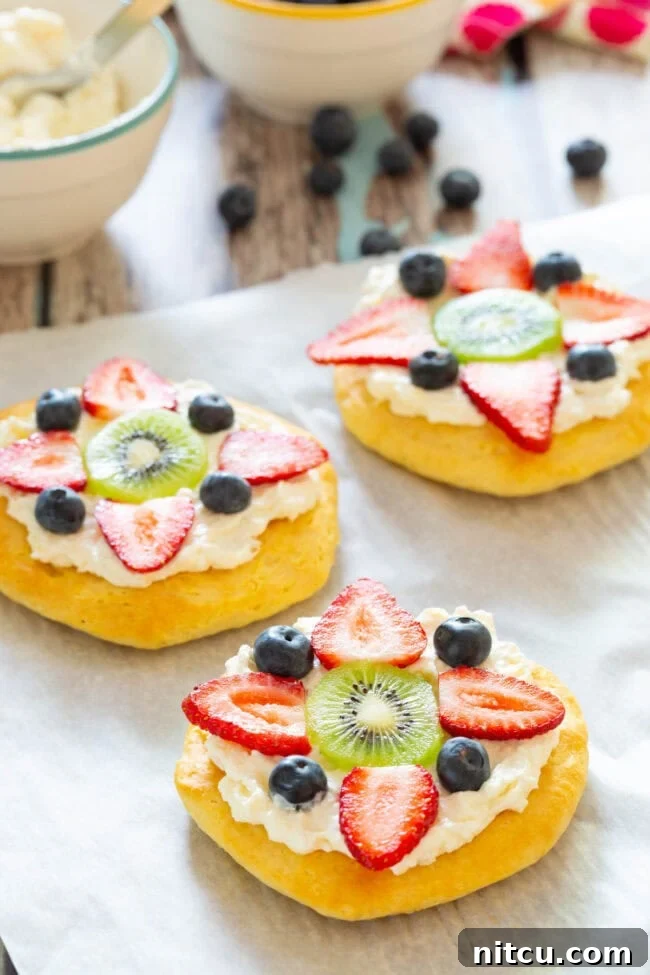 Close-up shot of a beautiful Fruit Pizza for Breakfast, garnished with fresh berries and kiwi slices.