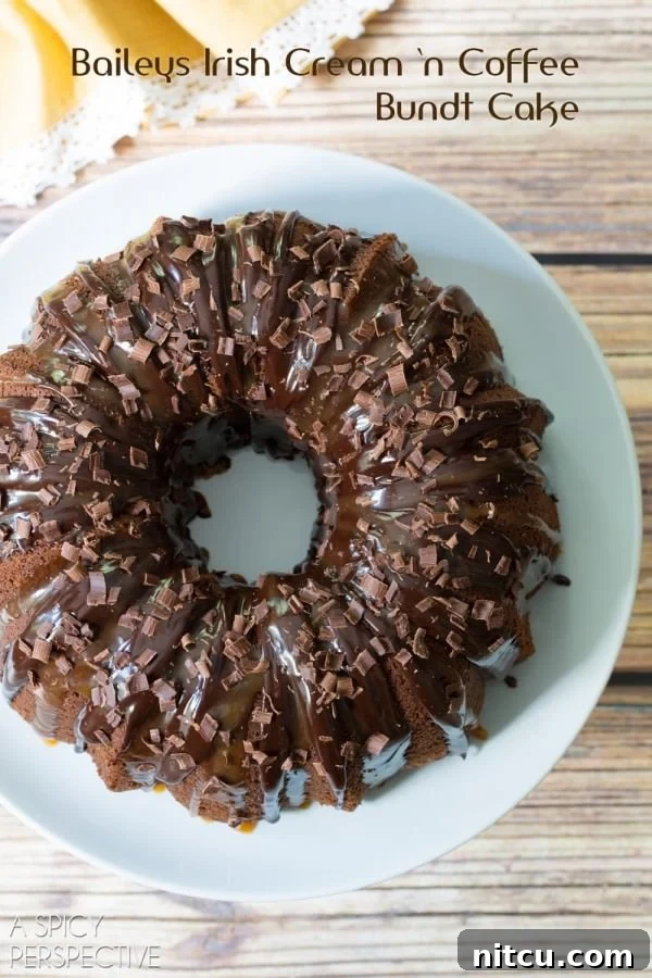 A beautifully decorated Baileys Irish Cream Bundt Cake, glistening with chocolate ganache and caramel drizzle, presented on a elegant white platter.