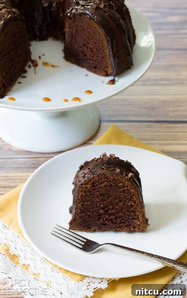 A delectable slice of Baileys Irish Cream Bundt Cake, revealing its soft, moist crumb and the perfect balance of chocolate and cream, served with a fork.