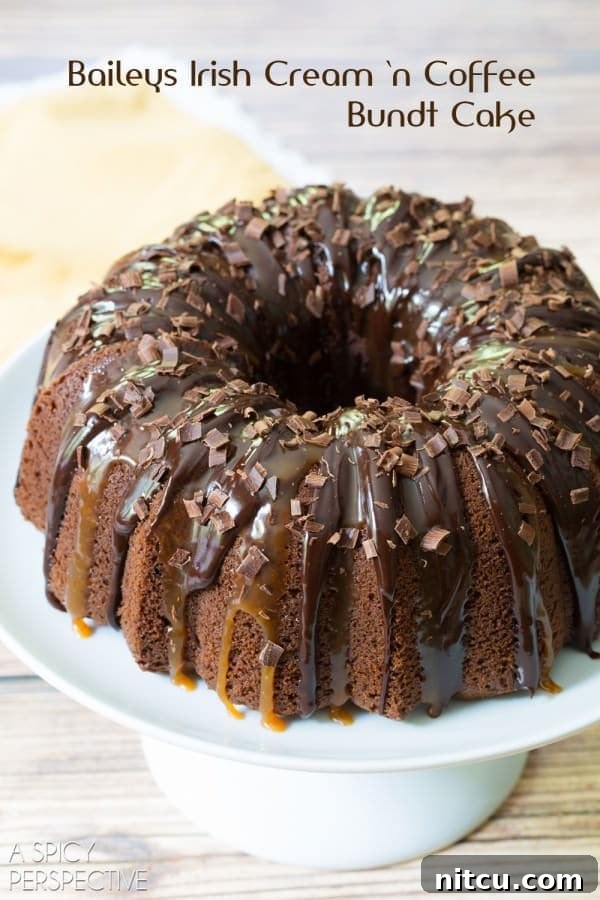 A close-up view of the Baileys Irish Cream Bundt Cake on a platter, highlighting its intricate design and the glossy finish of its toppings.