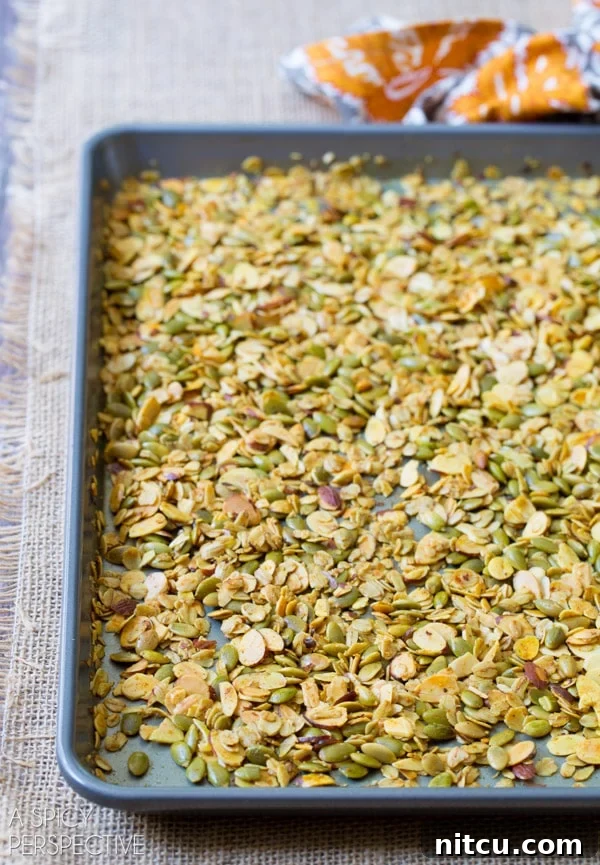 Homemade granola spread out on a baking sheet.