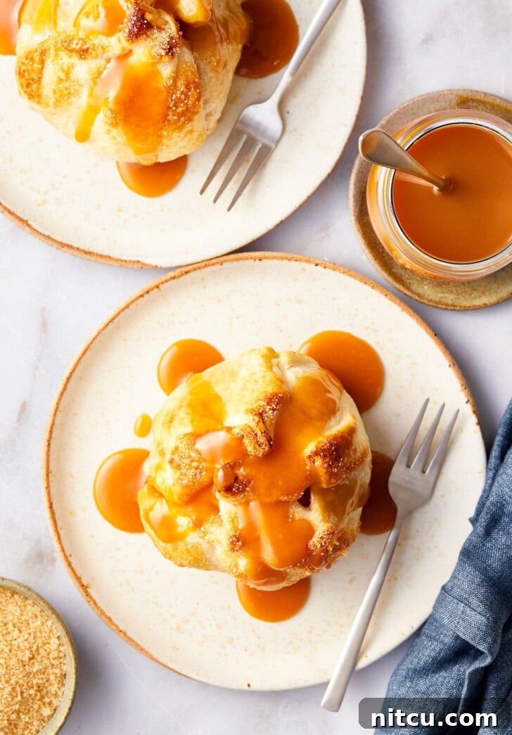 Baked apple recipe after being baked on a plate with caramel on top, overhead shot.