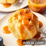 Simple baked apple recipe with puff pastry on a plate, caramel sauce over the top