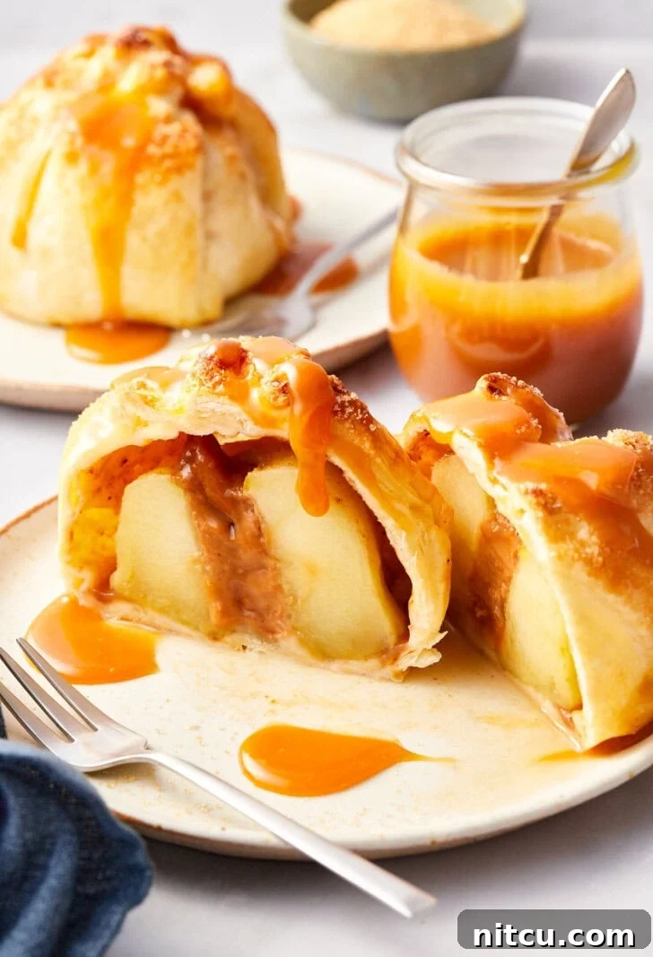 Simple baked apples in puff pastry on a plate, cut in half.