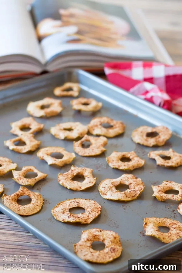 Side view of baked apple chips on a baking sheet.