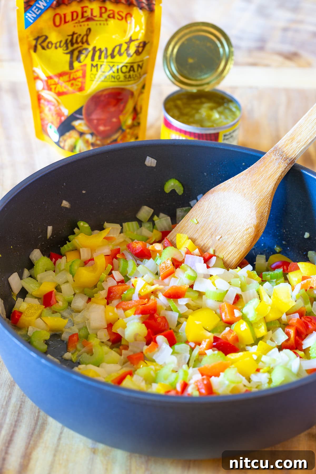 Cornbread dressing with vibrant, sautéed vegetables for stuffing in a large skillet