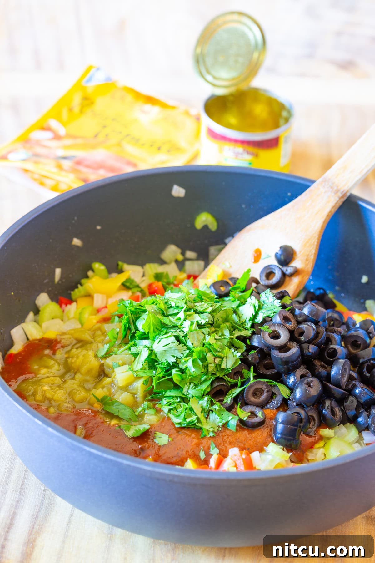 Homemade cornbread stuffing ingredients shown in a skillet, mixing vegetables and cornbread pieces