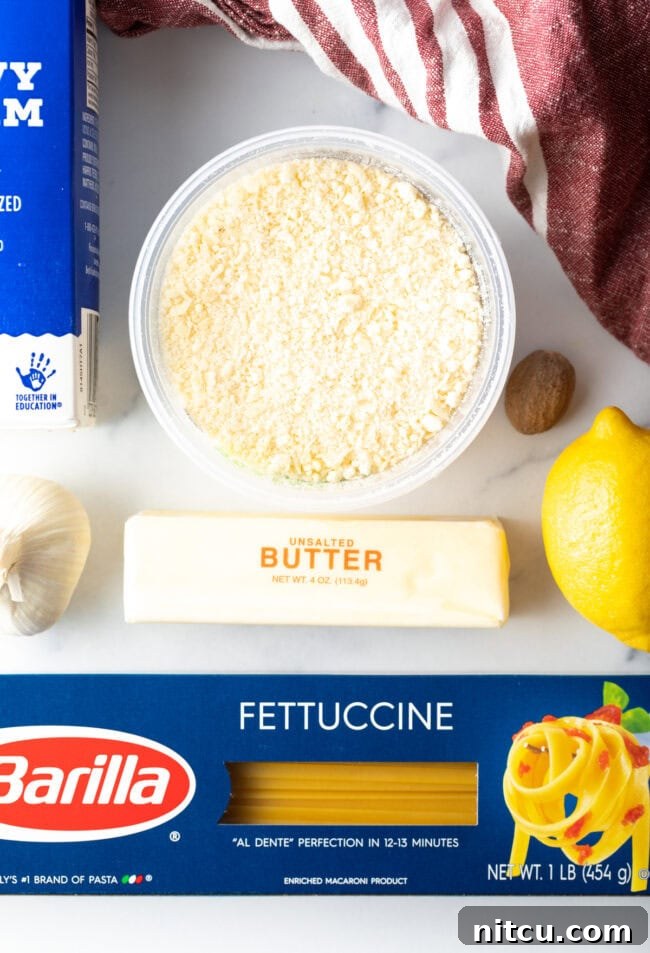 Key ingredients for homemade Alfredo sauce laid out on a wooden table