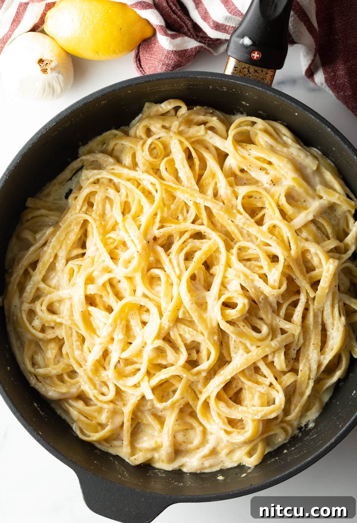 Plate of homemade Fettuccine Alfredo ready to serve with a fork