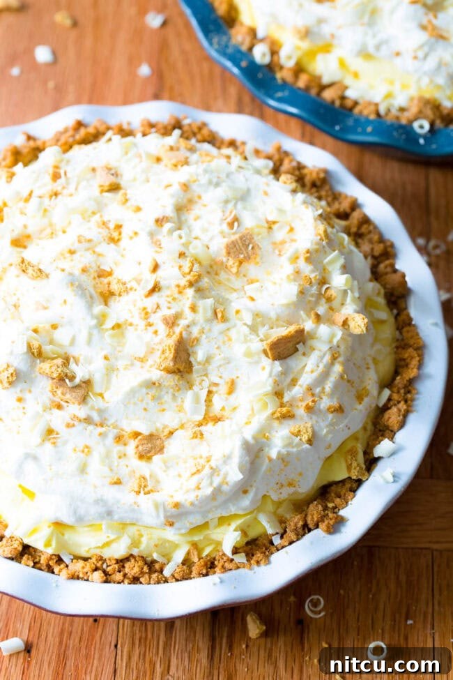 Close up shot of lemon cream pie in a white pie dish.