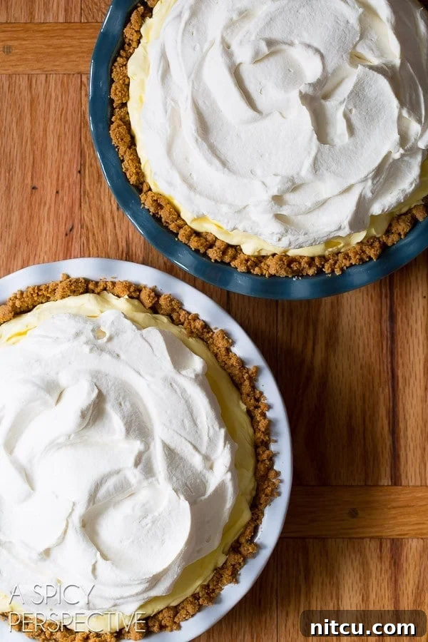Lemon cream pies before getting a sprinkle of graham crackers on top of the cream. 