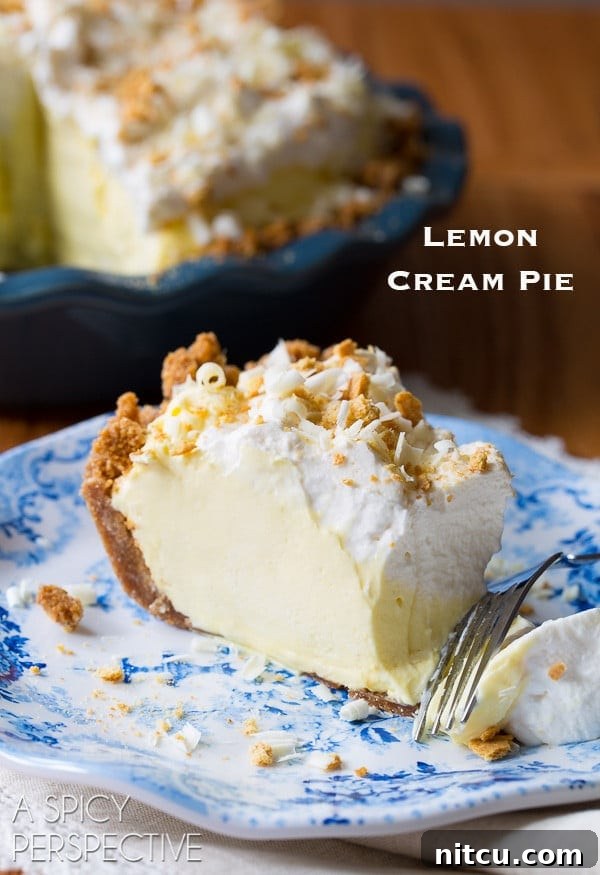 Slice of lemon cream pie on a plate with the words "lemon cream pie" in the corner. 