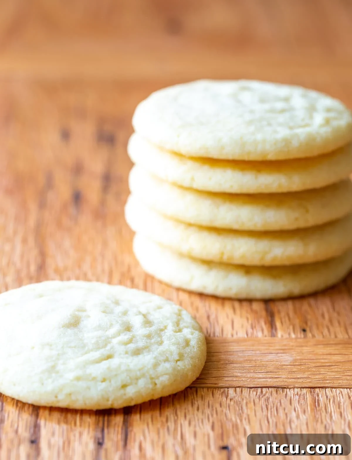 Side view of a stack of the world's best sugar cookies recipe, showing off their perfectly baked texture and golden-brown undersides.