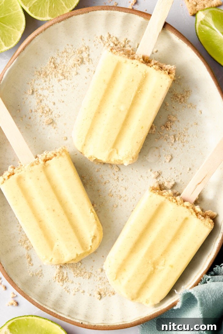 5-Ingredient Key Lime Pudding Pops - lime popsicles on a plate with graham cracker crust garnish