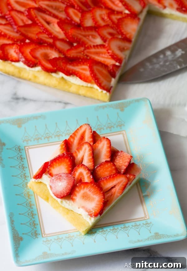 Overhead view of a finished strawberry fruit pizza, garnished and ready.