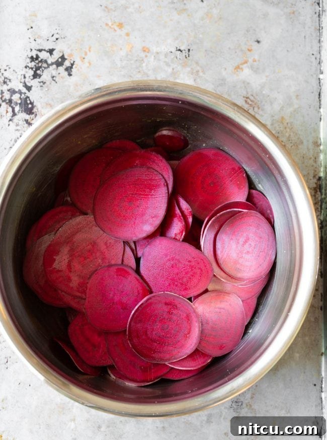 The beetroot “sweating” in salt and oil in a metal bowl to release moisture. 