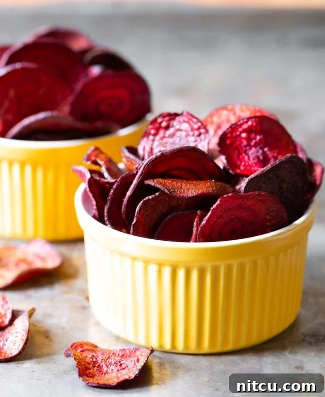 Final beet chips recipe looking crispy and bright in yellow bowls. 