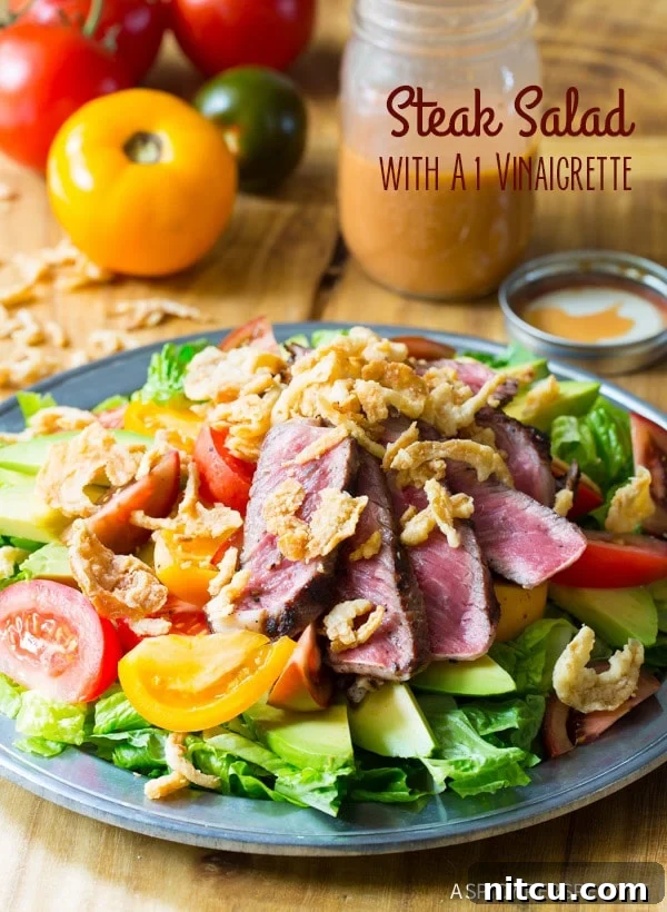 A vibrant grilled steak salad, generously topped with slices of ripe avocado, juicy tomatoes, and golden crispy fried onions, presented on a blue plate. Large, fresh tomatoes are visible in the soft-focus background, suggesting garden-fresh ingredients.