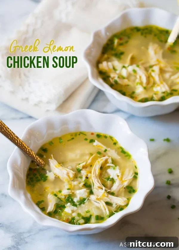 Two steaming bowls of Greek lemon chicken soup with fresh lemon slices and feta on a kitchen counter, ready to be enjoyed.