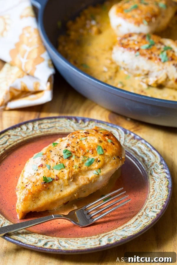 Top down view of perfectly cooked garlic lime chicken breast on a plate, garnished with fresh chopped parsley.
