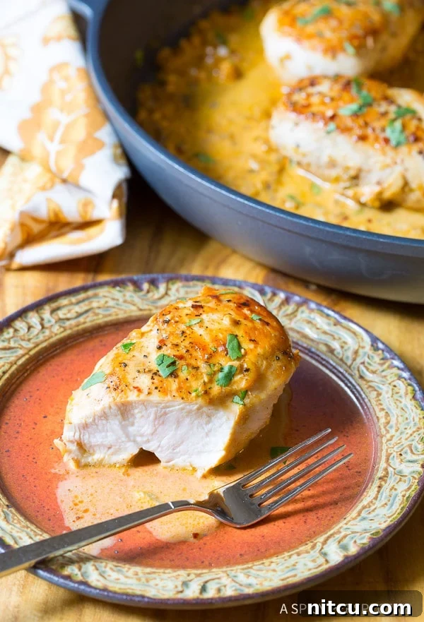 Plated garlic lime chicken with a fork taking a bite, showing the tender interior.