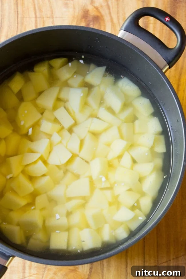 Chopped up potatoes in a pot ready to boil and become tender