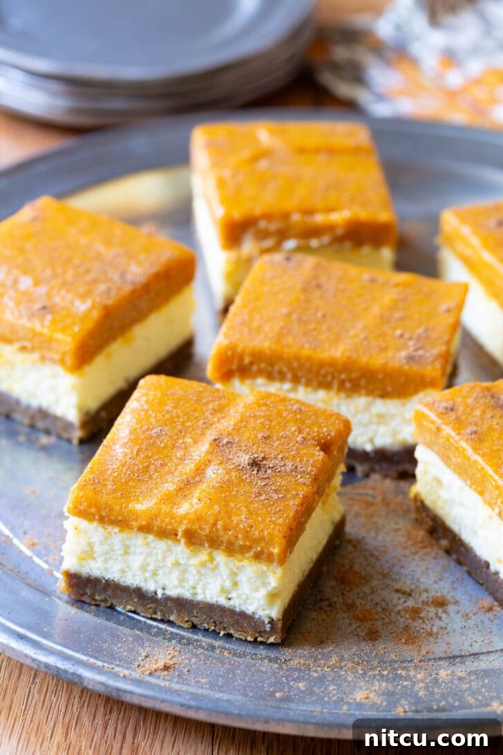 Elegant slices of pumpkin cheesecake on a rustic serving tray, perfect for a fall gathering.