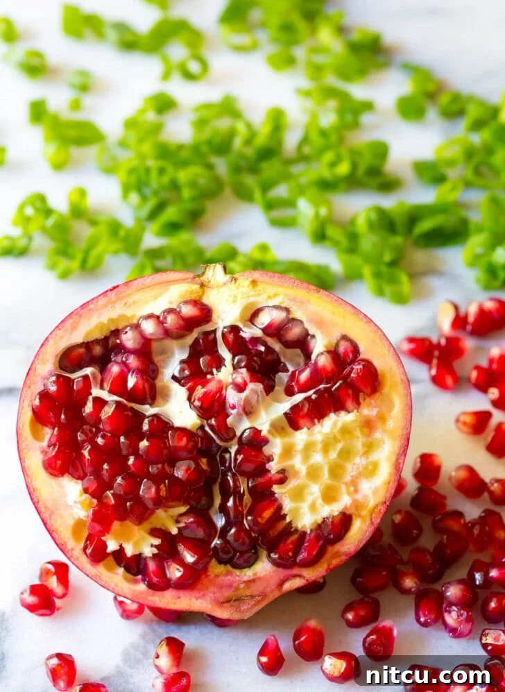 Half of a pomegranate with the seeds popping out. 