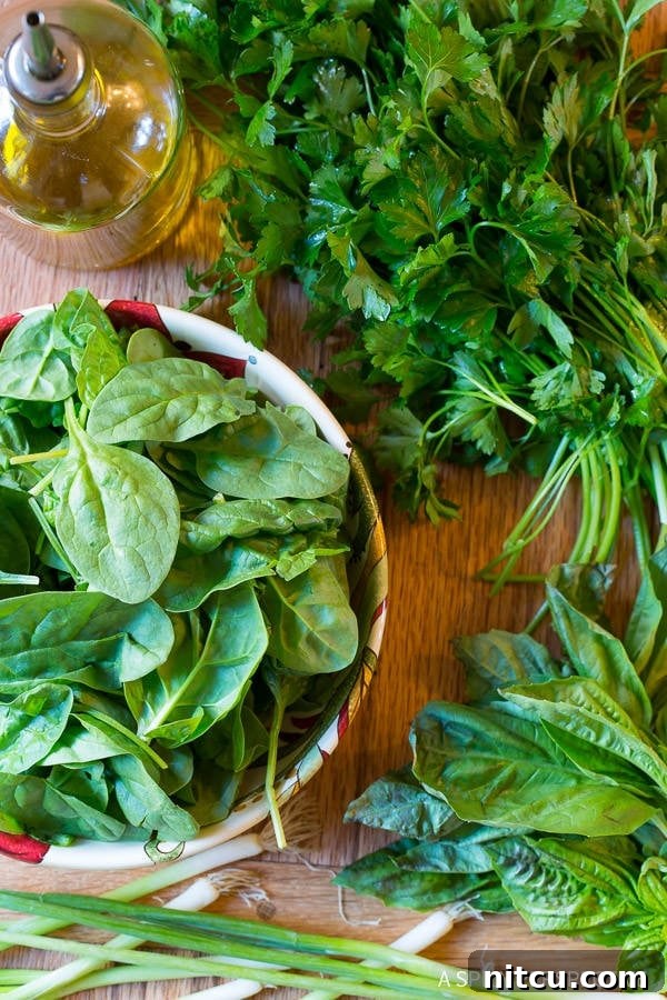 Overhead shot of spinach, basil, parsley and scallions on board.