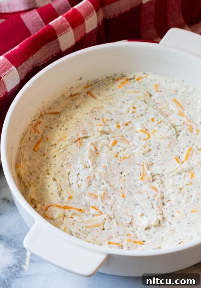 White dish with cream cheese mixture spread evenly in the bottom.