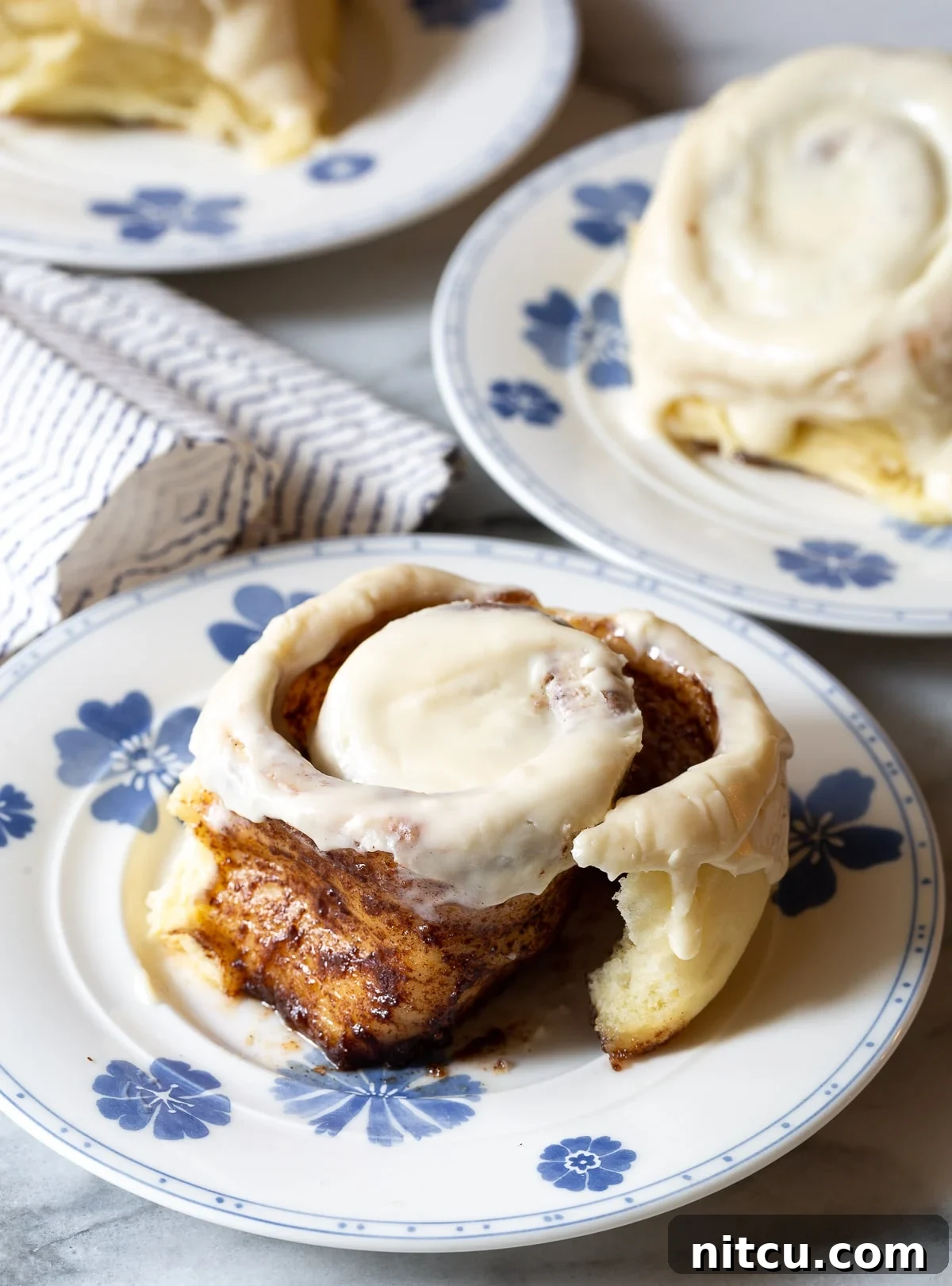 Multiple cinnamon buns arranged on plates, ready to be served.