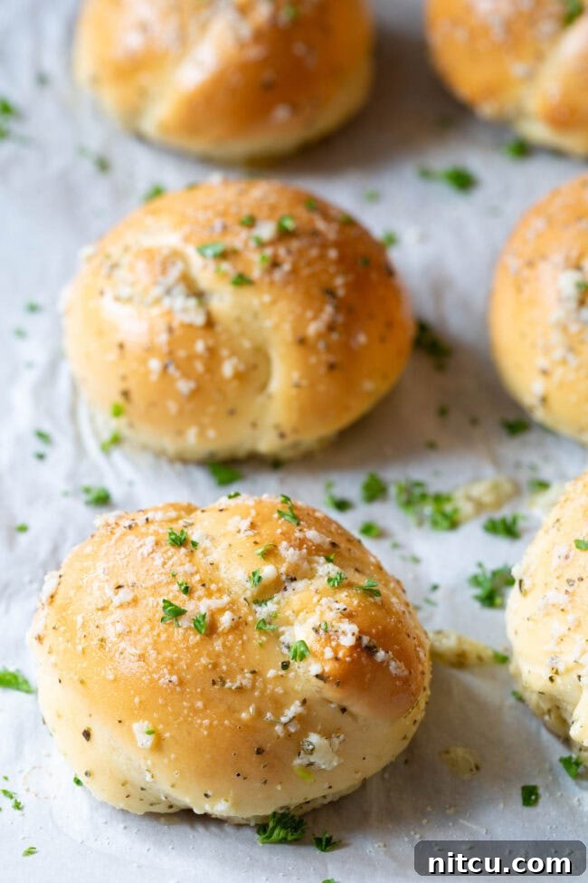 Garlic knots neatly lined up on a baking sheet, ready for baking.
