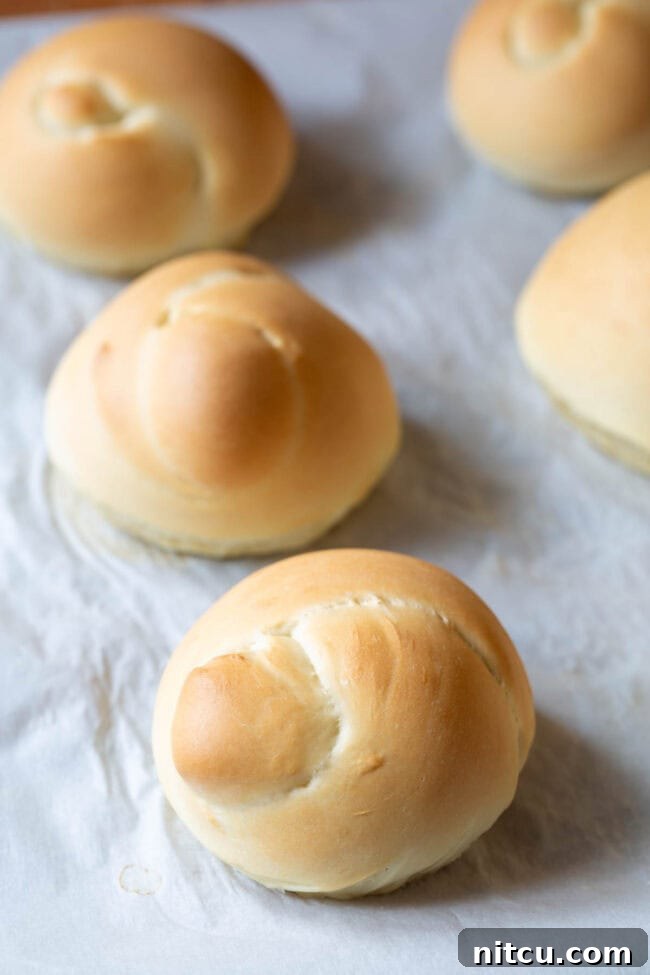 Freshly baked bread knots, golden and warm, awaiting their delicious garlic herb butter coating.