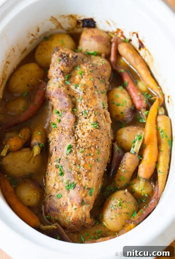 Crock Pot Pork Loin with Vegetables, freshly slow-cooked and garnished with parsley