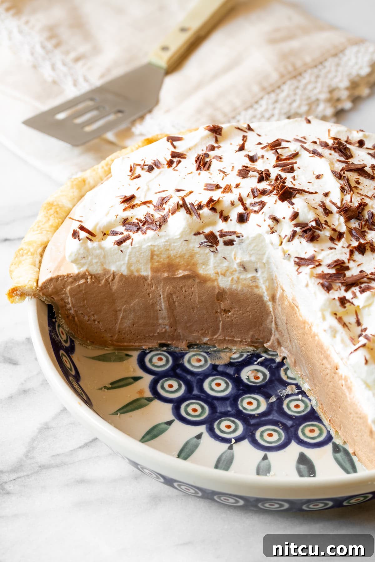 A whole easy French Silk Pie recipe, cut open to reveal the rich chocolate filling and thick whipped cream layers.