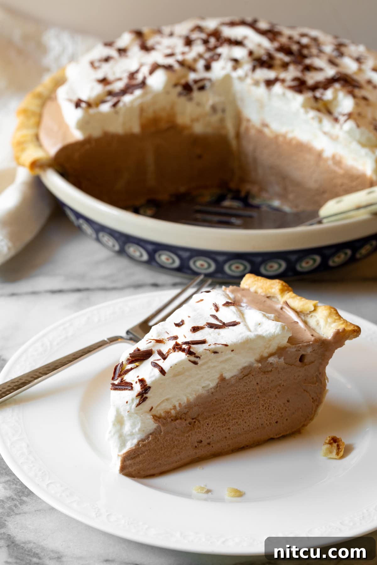 A stunning shot of a chocolate pie, showcasing its smooth filling and fluffy whipped topping.