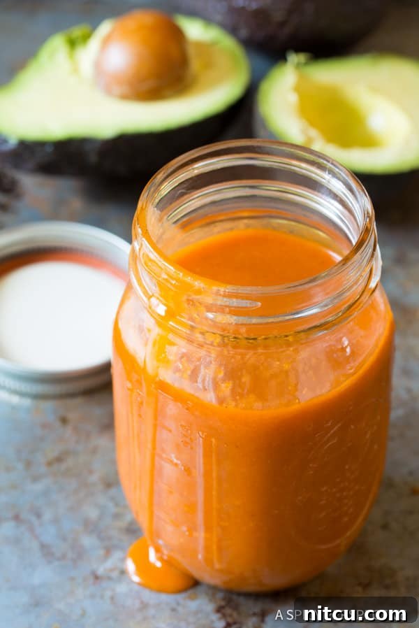 Homemade Catalina Dressing in a clear glass mason jar, showcasing its vibrant color.