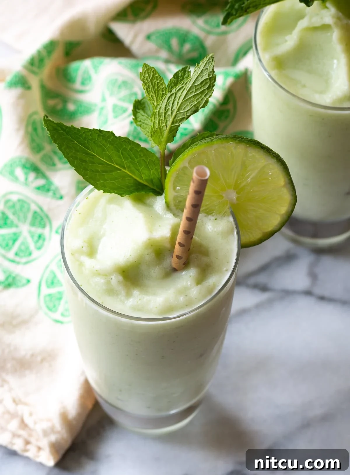 Delicious Frozen Coconut Mojito in a glass with mint and lime garnish