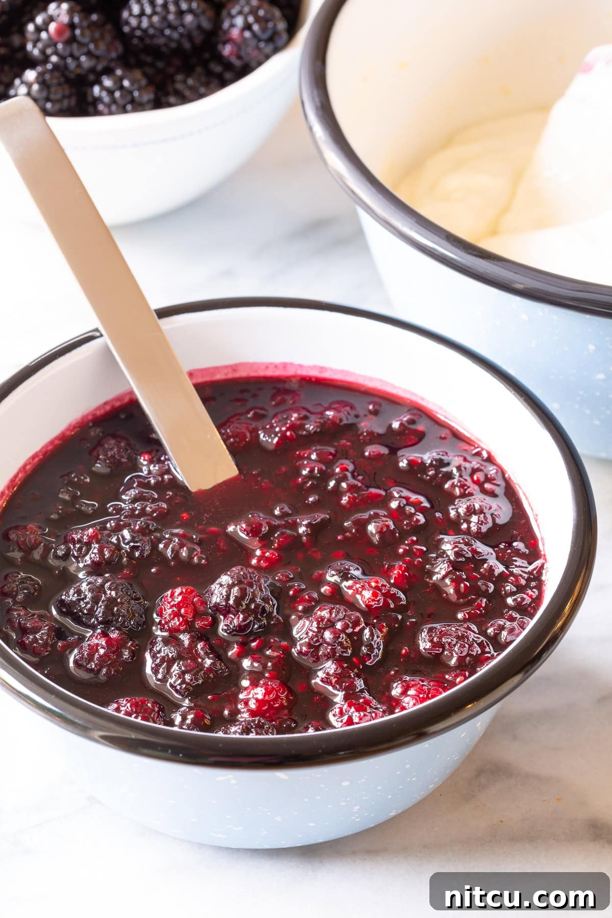 Fresh blackberry sauce ingredients mixed in a bowl, ready for simmering